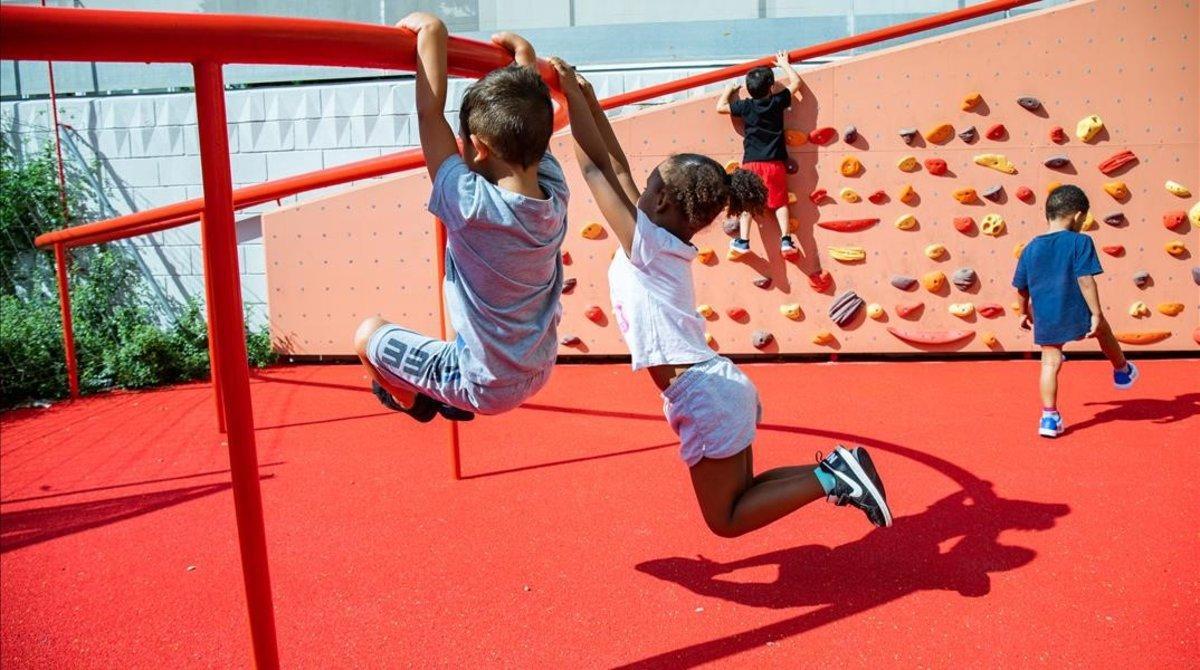 Niños jugando en el nuevo rocódromo frente a la Escola La Pau.