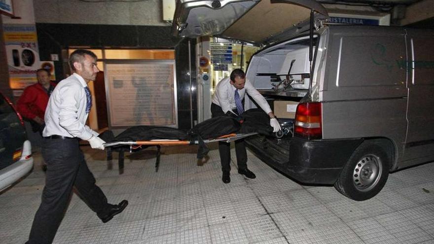 Los empleados de la funeraria trasladan el cadáver a un furgón, ayer por la noche en Ponteareas.