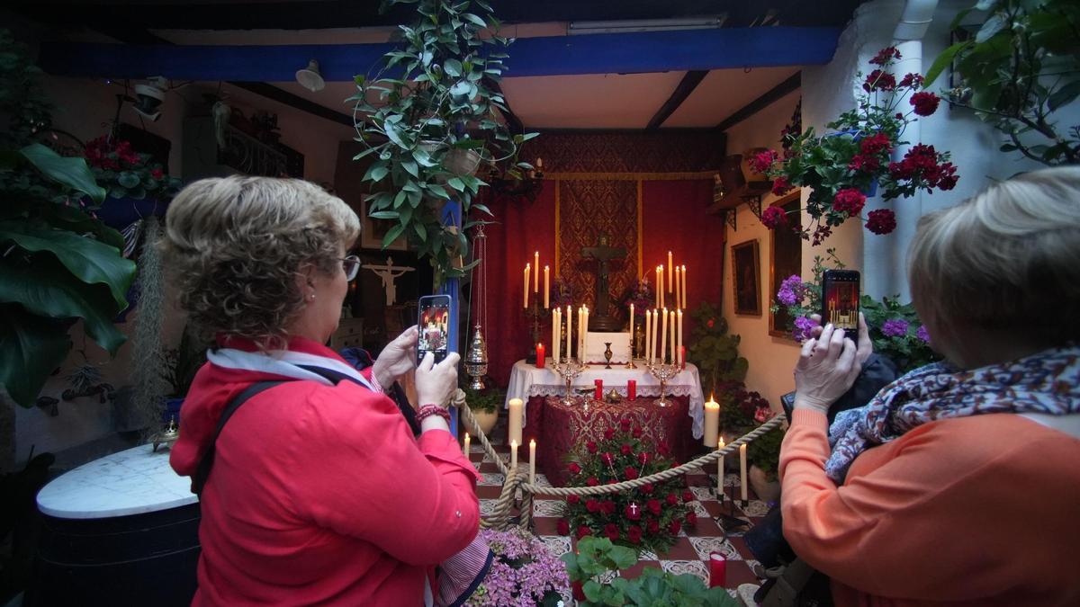 Unas mujeres fotografía un altar el Jueves Santo.