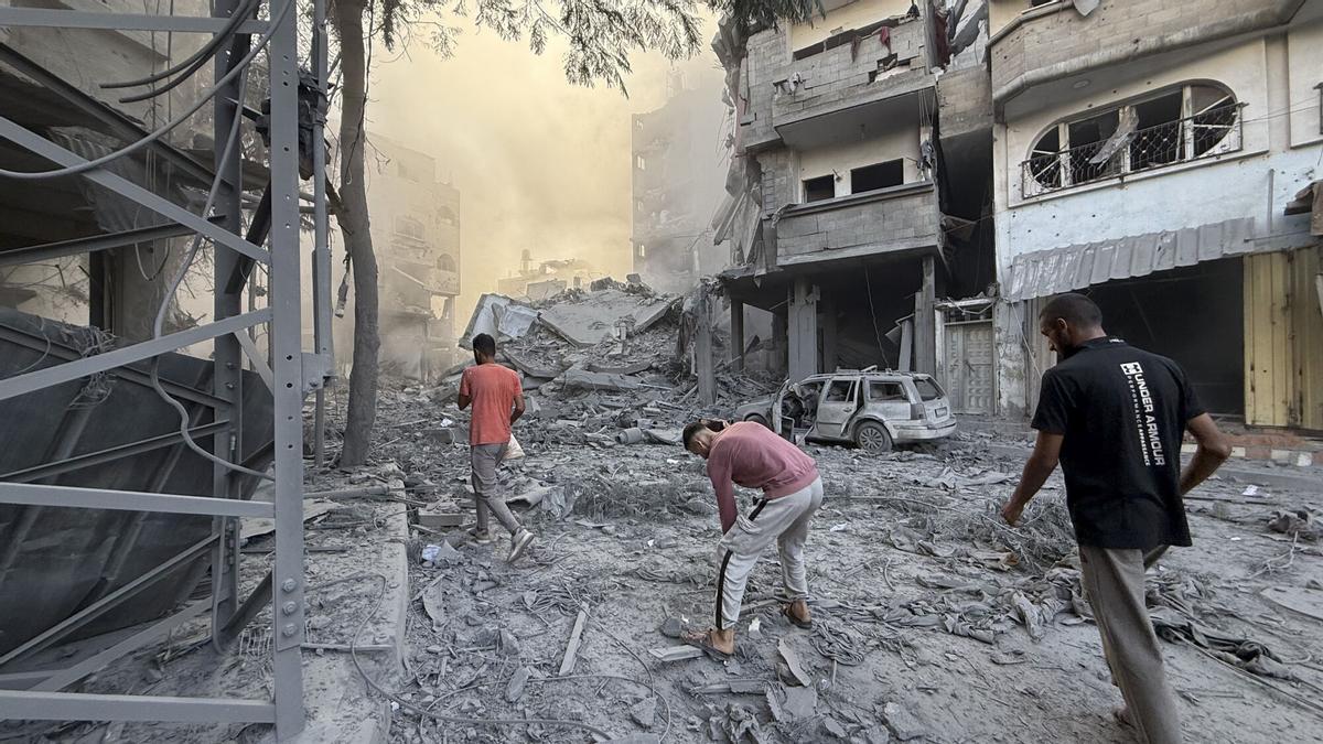 BUREIJ (GAZA Y CISJORDANIA), 19/10/2025.- Varios hombres caminan por los escombros tras uno de los ataques lanzados este domingo por Israel en Gaza.