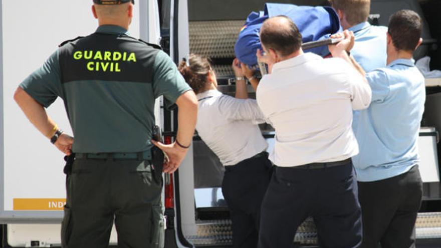 Uno de los cuerpos es trasladado desde el chalet en presencia de la Guardia Civil.