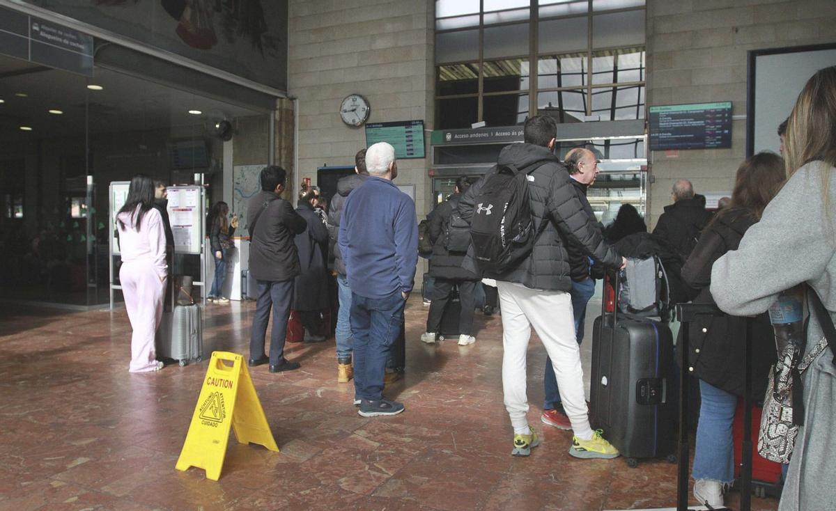 Pasajeros esperan la llegada de su ten, mientras en la pantalla las frecuencias aparecen canceladas o retrasadas. | IÑAKI OSORIO