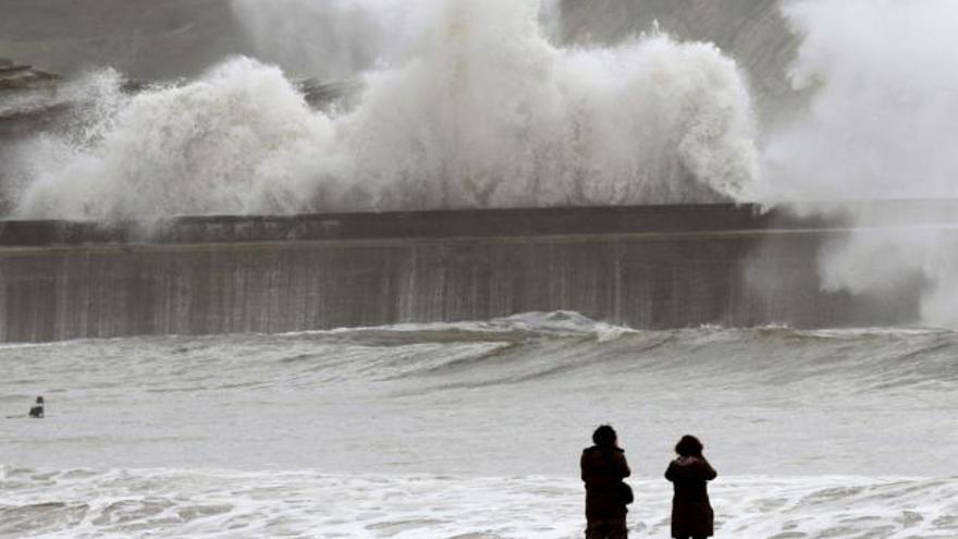 Dos personas contemplan el mar en una localidad costera vizcaina.