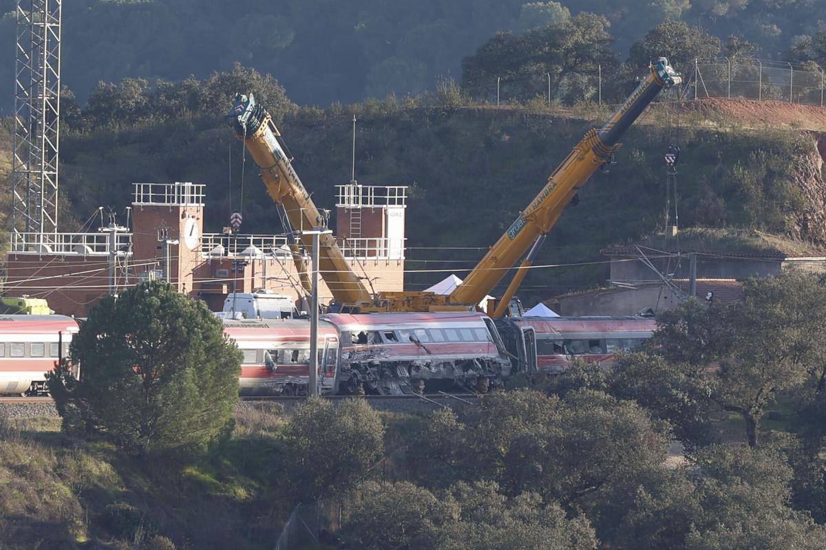 Una grúa trabaja en las inmediaciones del lugar de descarrilamiento.