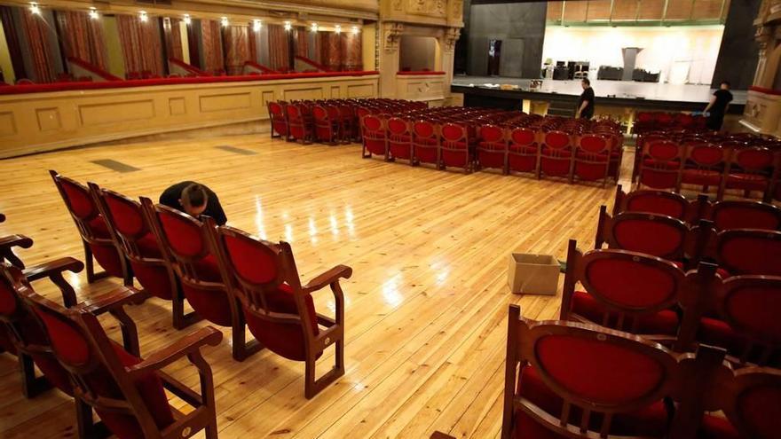 Los trabajadores, ayer, retirando las sillas del patio de butacas del teatro Palacio Valdés.