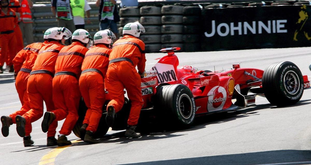 MNC034 MONTECARLO (MONACO) 27/05/06. Mecánicos de Ferrari empujan el coche del piloto alemán de Fórmula Uno Michael Schumacher durante la tercera sesión de entrenamiento de cara al Gran Premio de Mónaco en el circuito urbano de Montecarlo, hoy sábado 27 de mayo. El Gran Premio de Mónaco de Fórmula Uno se celebra mañana domingo 28 de mayo. EFE/Kerim Okten. michael schumacher. ferrari. gp monaco 2006. deportiva asistencia mecanicos 2006. circuito de montecarlo