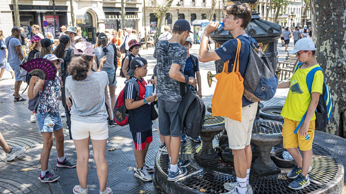 Ola de calor en Barcelona. turistas se refrescan en la fuente de canaletas así como también sus mascotas.