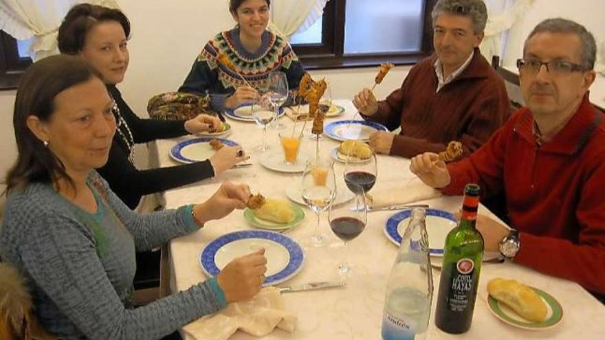 Un grupo de visitantes degusta brochetas de langostino con corteza de maíz en uno de los restaurantes llaniscos.