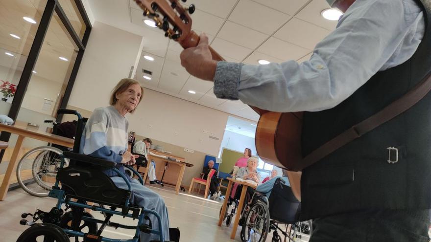 El músicu con una de les residentes del Vallín. | Mara Villamuza