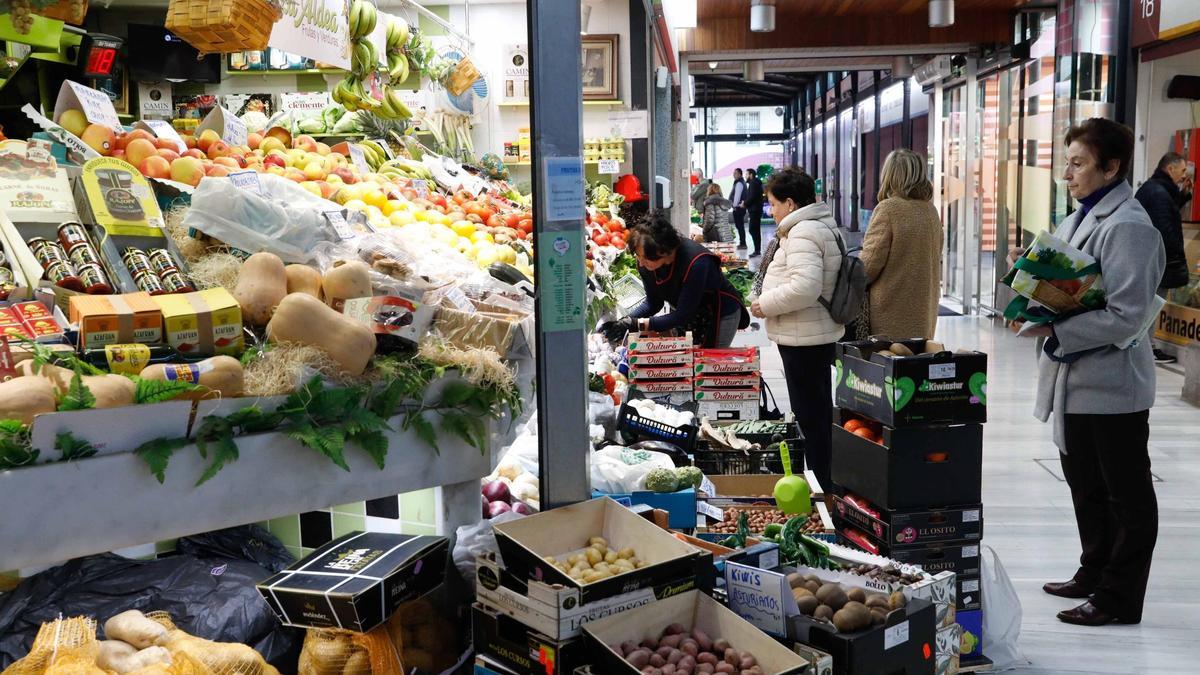 Clientes en un puesto del mercado de la plaza Hermanos Orbón.