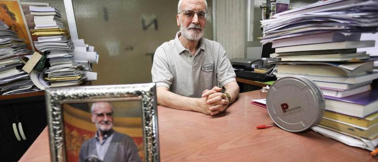 Juan Bonifacio Lorenzo posa en su despacho junto a una foto de la entrega del galardón que recibió en Avilés por su trayectoria en el cine asturiano.