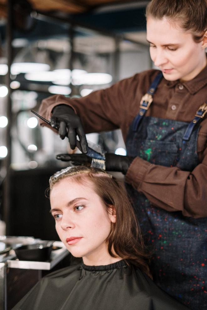 Una chica tiñéndose el pelo en una peluquería