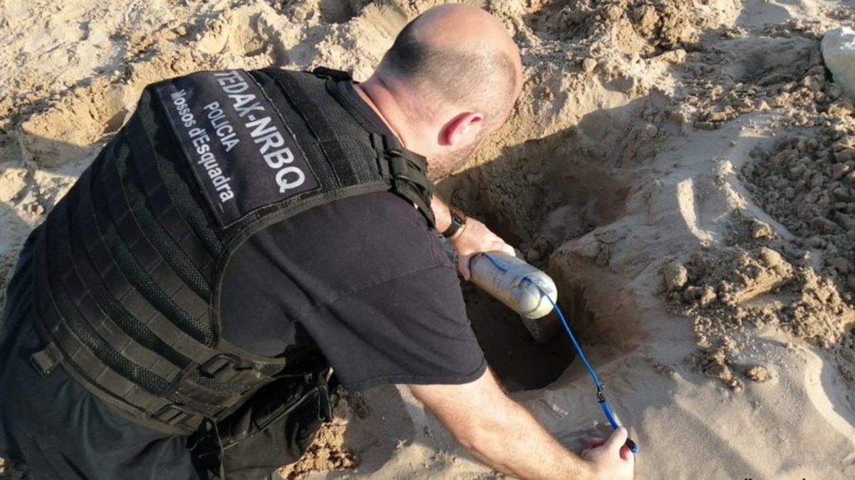 Un agente de los Tedax, con el artefacto hallado en la playa de la Arrabassada de Tarragona, el 29 de junio del 2020