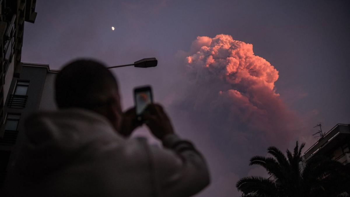 Un vecino del Valle de Aridane hace una fotografía con su móvil a una nube creada por la erupción.