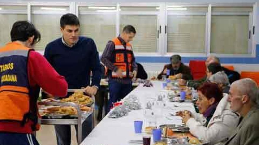 Voluntarios de Protección Civil sirven las mesas en el colegio Corazón de María.