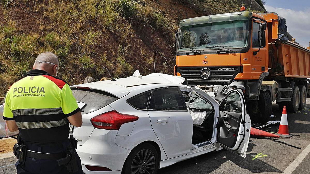 Un mosso de Trànsit durant les tasques d’investigació d’un accident mortal a Bescanó. | ANIOL RESCLOSA