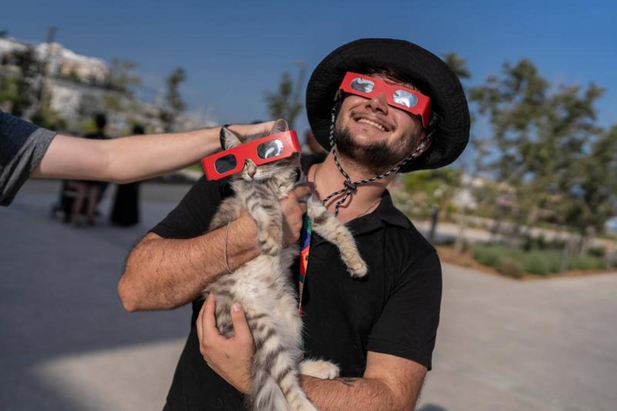 Visitantes y aficionados a la observación astronómica esperan en el Port de la Maria, en Tarragona, para contemplar el eclipse total de Sol.