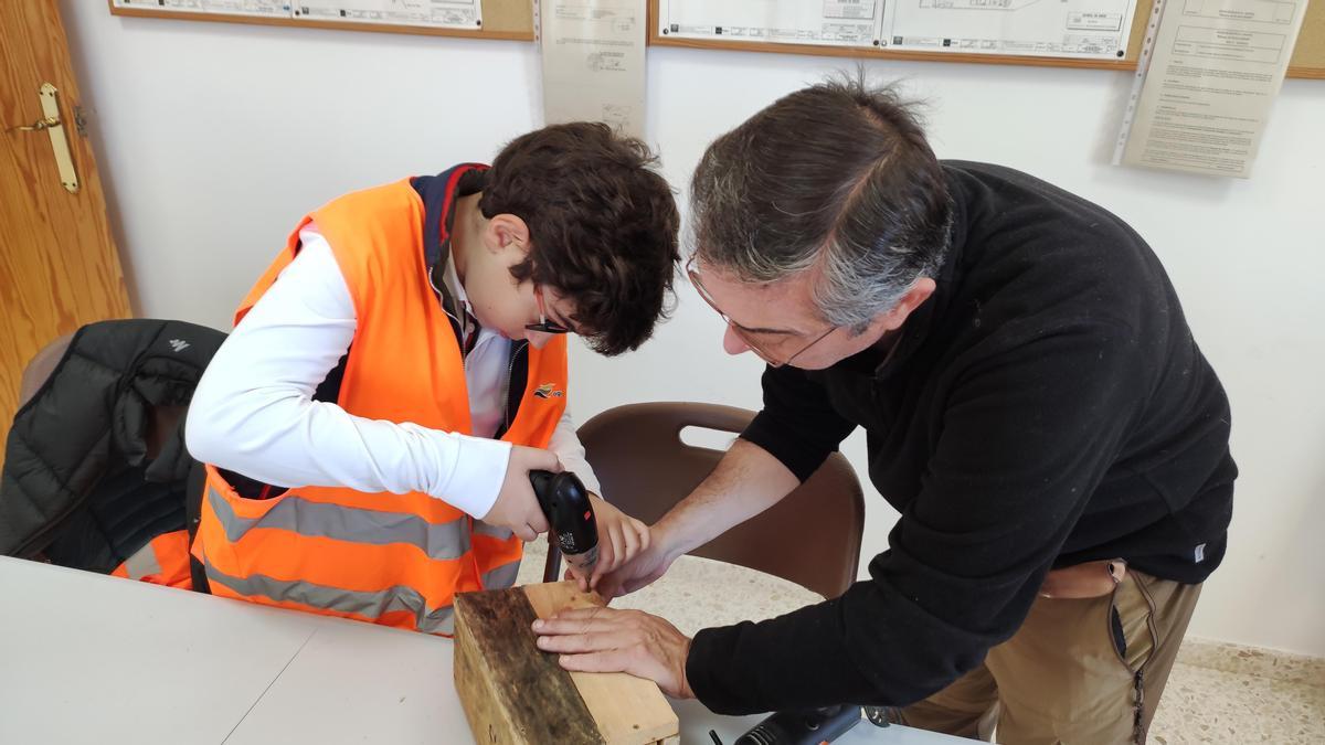 Un niño termina de cerrar la caja-nido que ha construido.