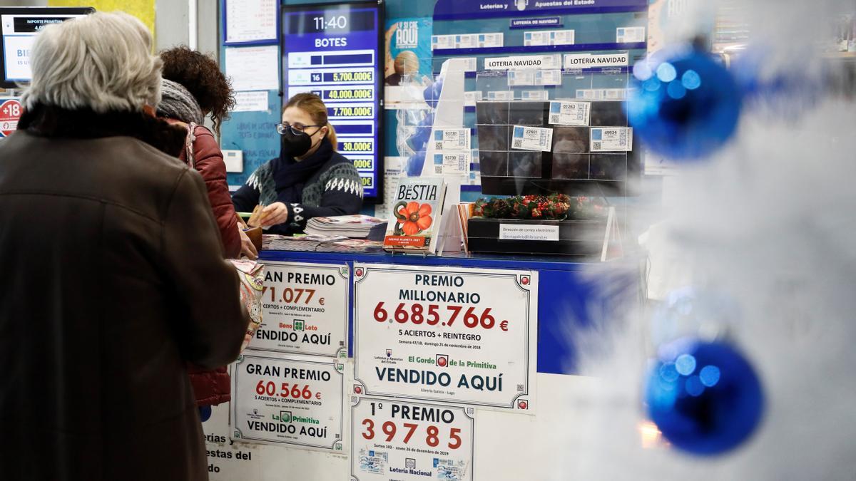 Un cliente comprando sus décimos de Lotería de Navidad en un establecimiento.