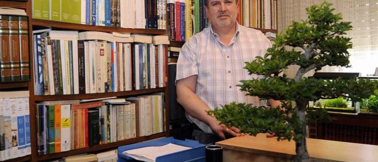 César Gómez Buxán, con uno de sus bonsais, en la biblioteca de su casa. // Bernabé/Javier Lalín