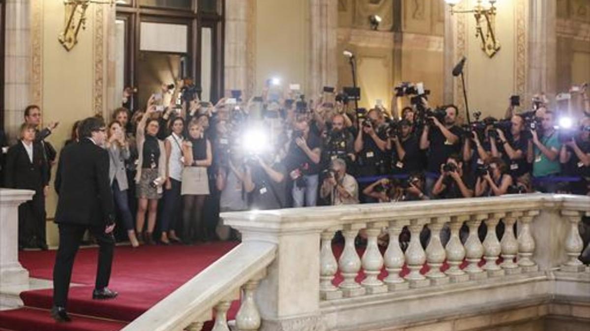Puigdemont llega al Parlament entre una nube de fotógrafos, el martes, antes de su comparecencia en el pleno.