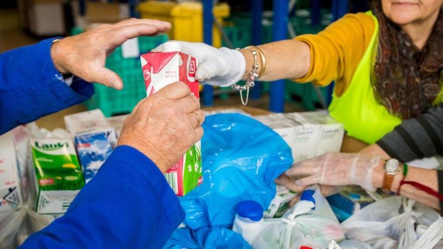 Una mujer acude a un banco de alimentos para poder comer.