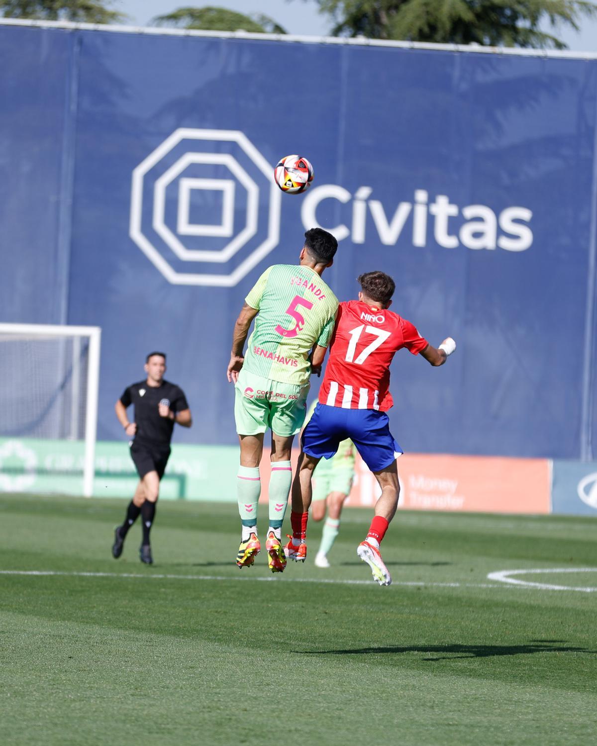 El malacitano Juande disputa un balón aéreo al delantero colchonero Adrián Niño, este domingo, en el Cerro del Espino.