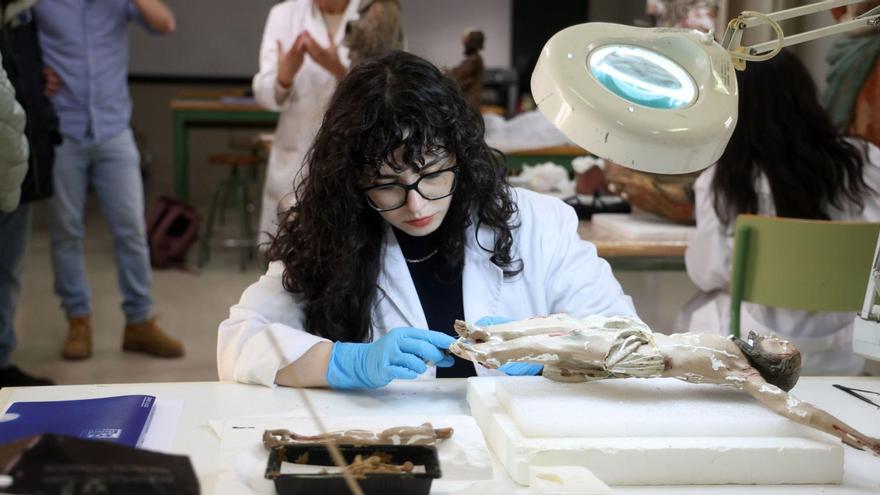 Una alumna trabaja sobre una talla en el taller de escultura de madera de la escuela. |  Gustavo Santos