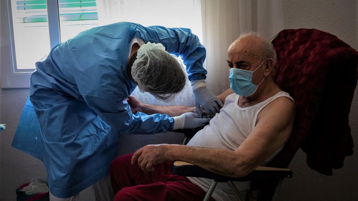 Un sanitario de la Unidad de Hospitalitació a Domicilio de Can Ruti atendiendo a un paciente con covid-19.