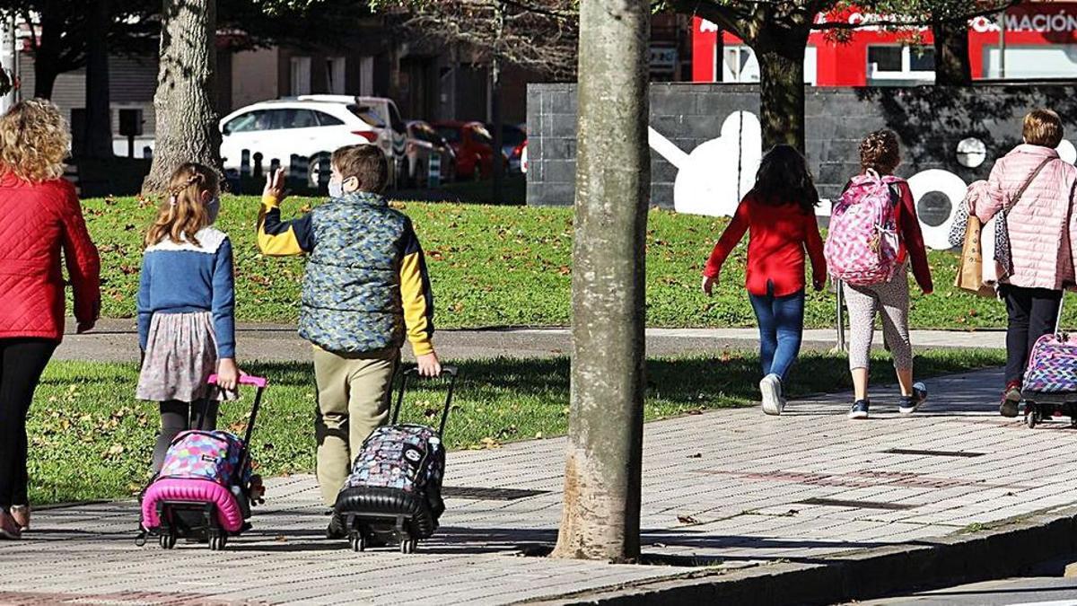 Escolares con sus mochilas tras la salida del colegio en Oviedo.