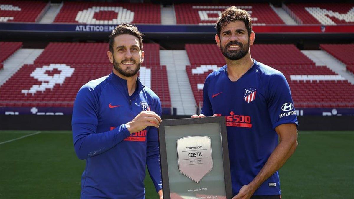 Diego Costa recibe de manos de su compañero Koke una placa conmemorativa.