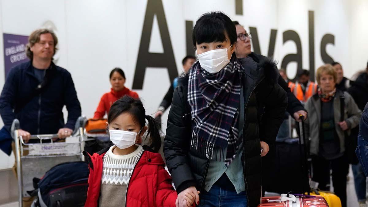 Pasajeros con mascarillas a su llegada al aeropuerto de  Heathrow, Londres,