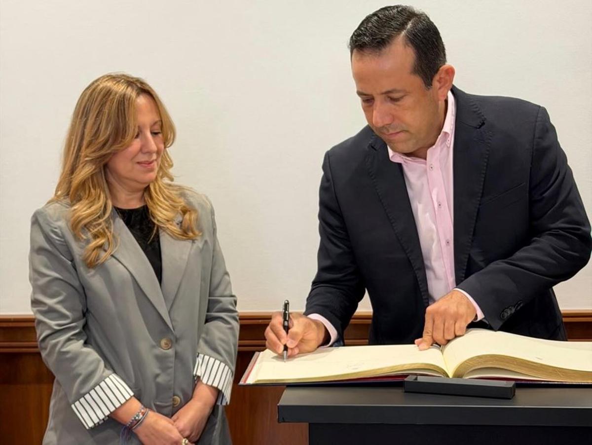 El alcalde de Tenerife junto a la presidenta insular, firmando en el libro de visitantes ilustres.