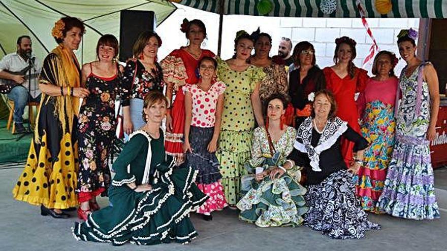 Un grupo de mujeres lucen con el traje flamenco.