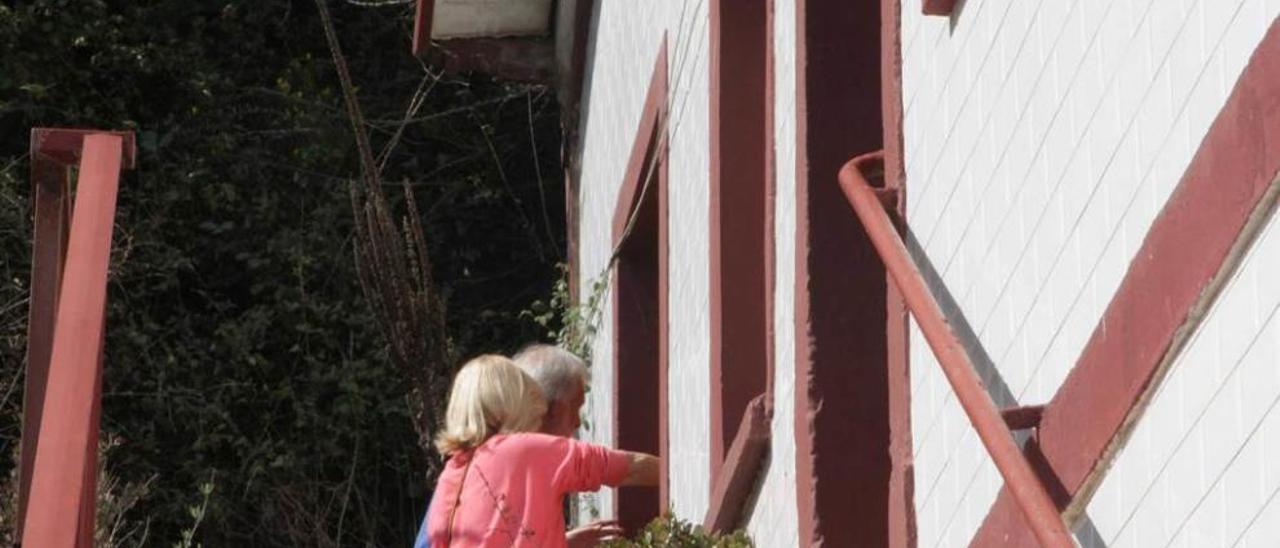 Alicia Prendes y Antonio Vázquez sellan la ventana por la que se introdujeron los supuestos ladrones que entraron en su vivienda.