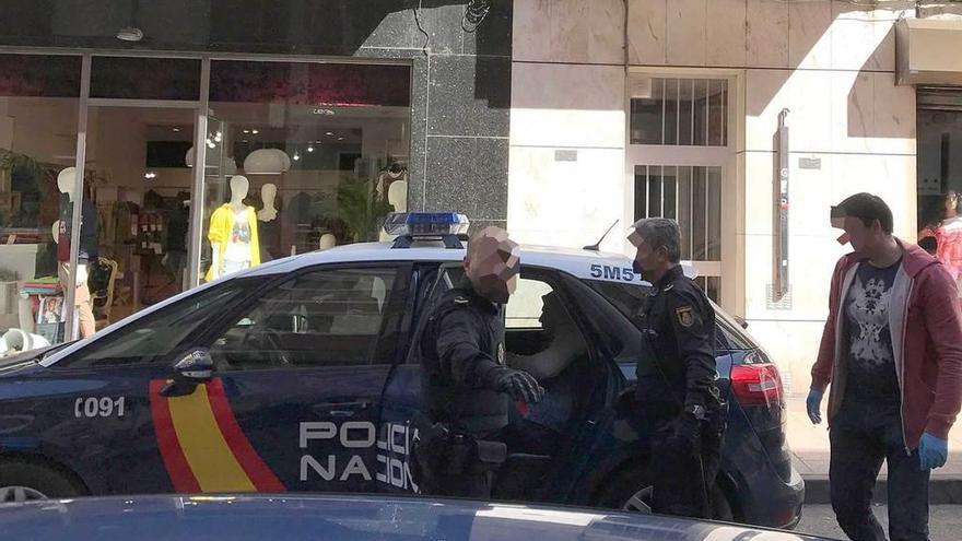 Agentes de Policía, ayer, con el detenido dentro del coche.