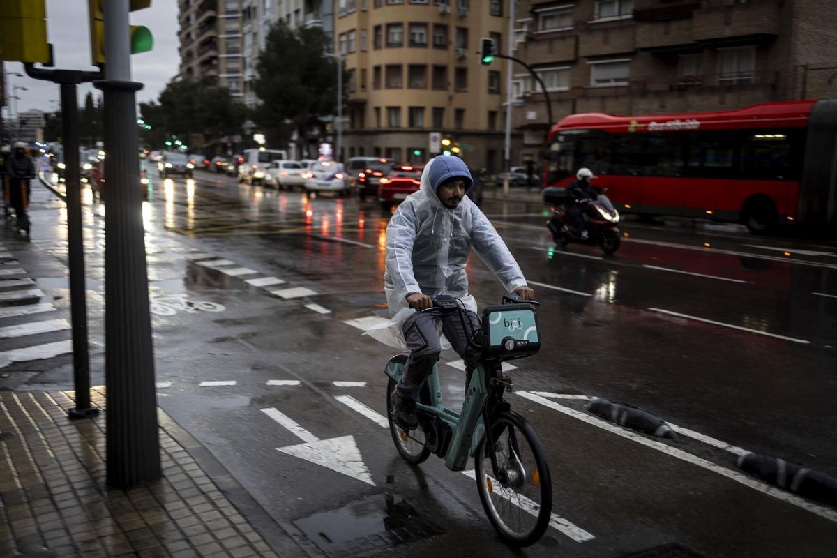Un usuario del servicio Bizi de Zaragoza en una jornada de lluvia en la capital aragonesa.