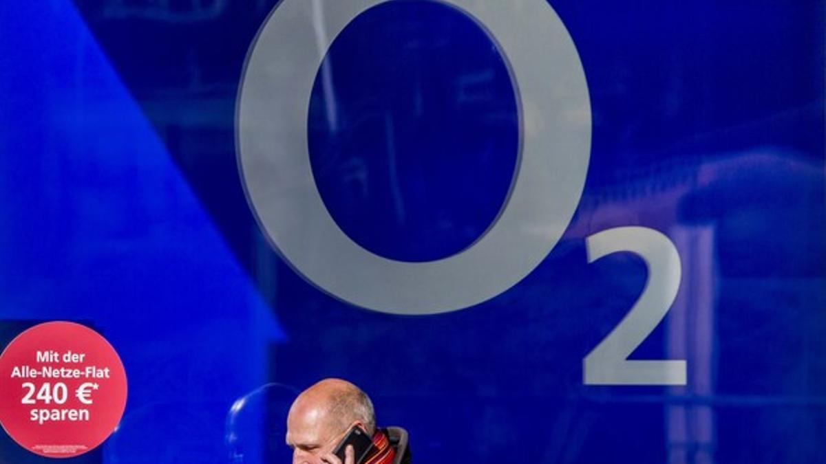 A man speaks on phone as he walks past O2 flagship store in Berlin