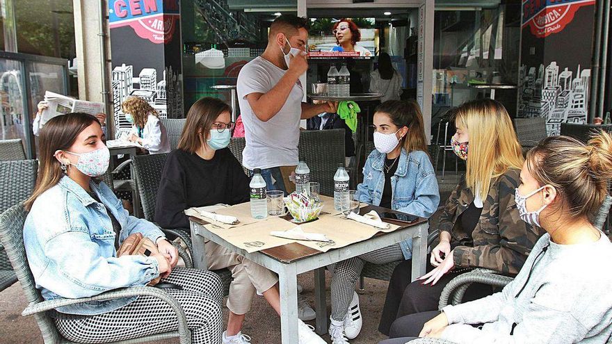 Cinco jóvenes en una terraza de un bar en el Parque de San Lázaro.