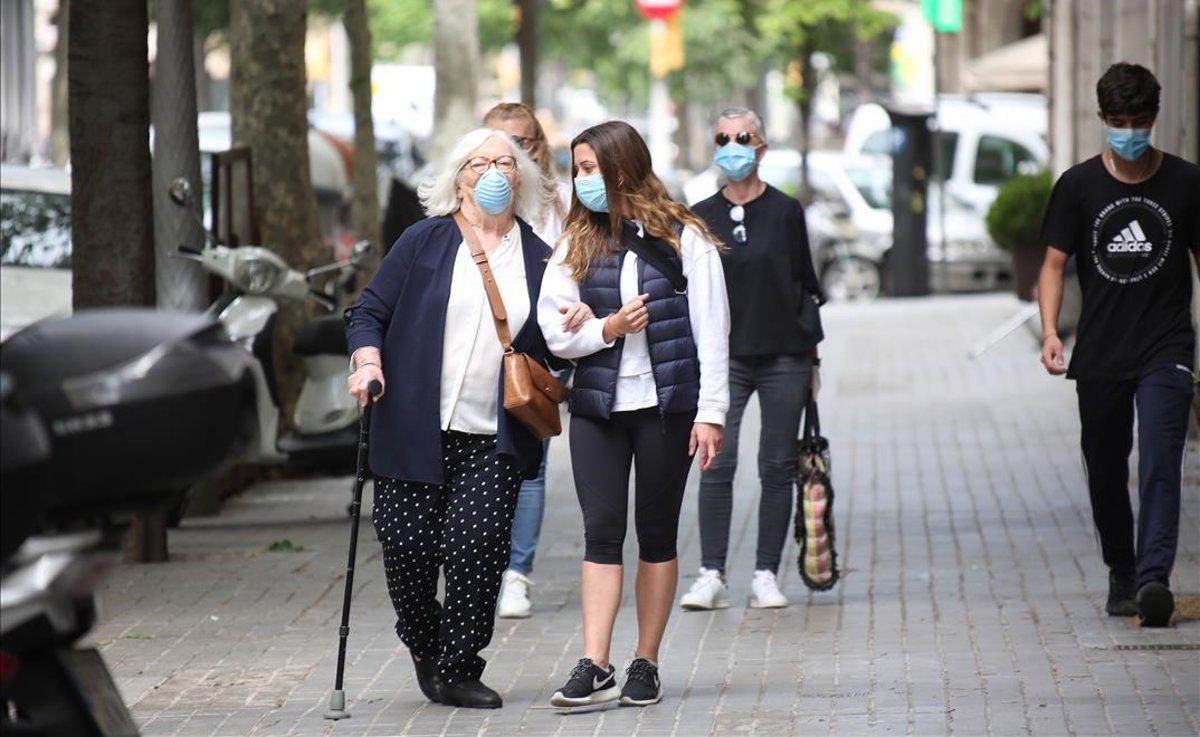 Una mujer mayor pasea por las calles de Barcelona, el primer día en que los abuelos podían salir a la calle.