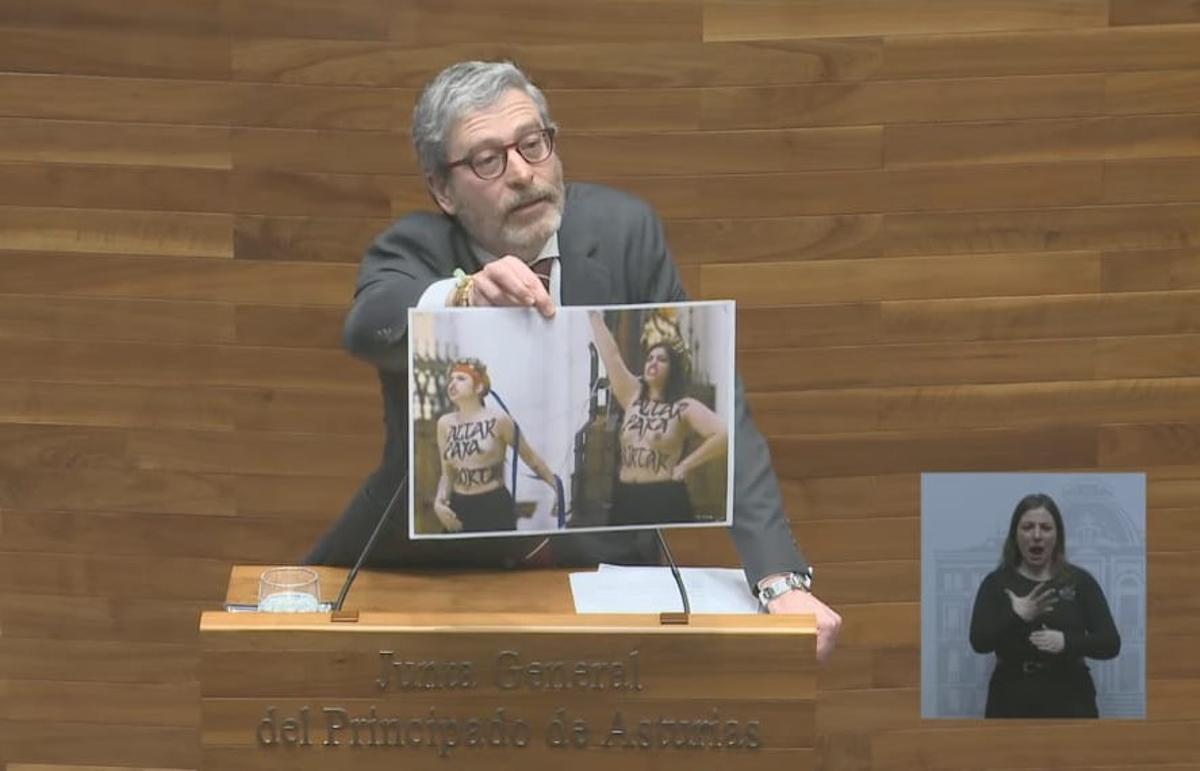 Javier Jové enseña una fotografía de dos activistas sin camiseta.