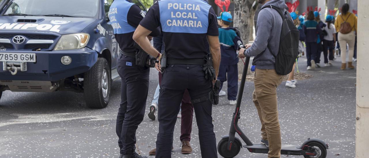 Agentes de la Policía Local de Santa Cruz informan a un ciudadano sobre las normas de uso del patinete.