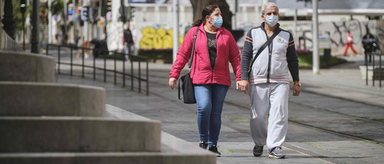 Dos personas pasean hoy domingo en Santa Cruz de Tenerife.