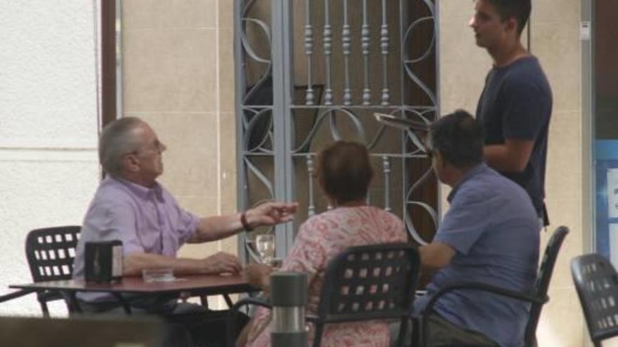 Un camarero atiende una mesa en el Centre Històric de Gandia.