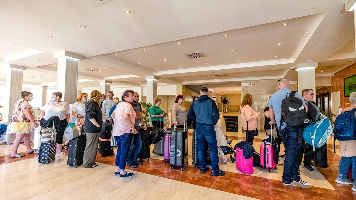 Turistas en la recepción de un hotel de Benidorm, esperando para hacer el registro.