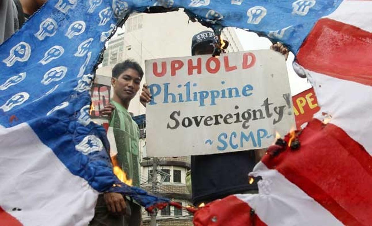 Un jove crema una bandera inspirada en la dels Estats Units durant una manifestació davant l’ambaixada nord-americana a Manila (Filipines). Els manifestants van demanar l’abolició de l’Acord de Visita Filipino-nord-americà i van denunciar la presència al país d’oficials i tripulació del USS Blue Ridge.