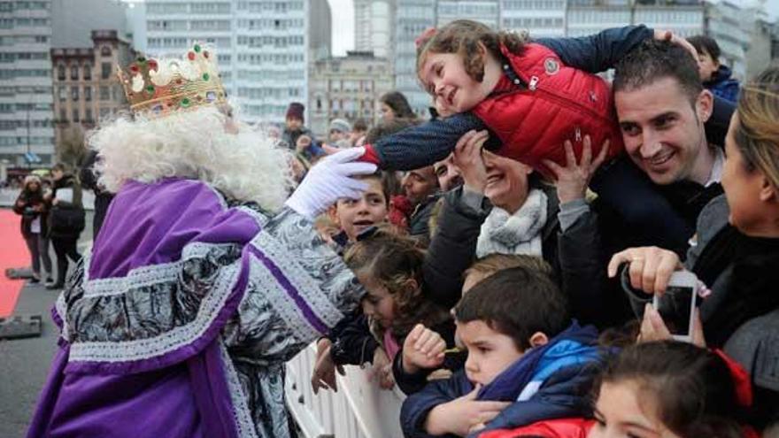 Uno de los Reyes Magos saluda a una niña durante la cabalgata de A Coruña de 2014. / C.Pardellas