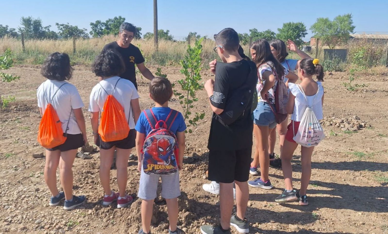 El director del taller enseñando a los niños un árbol.