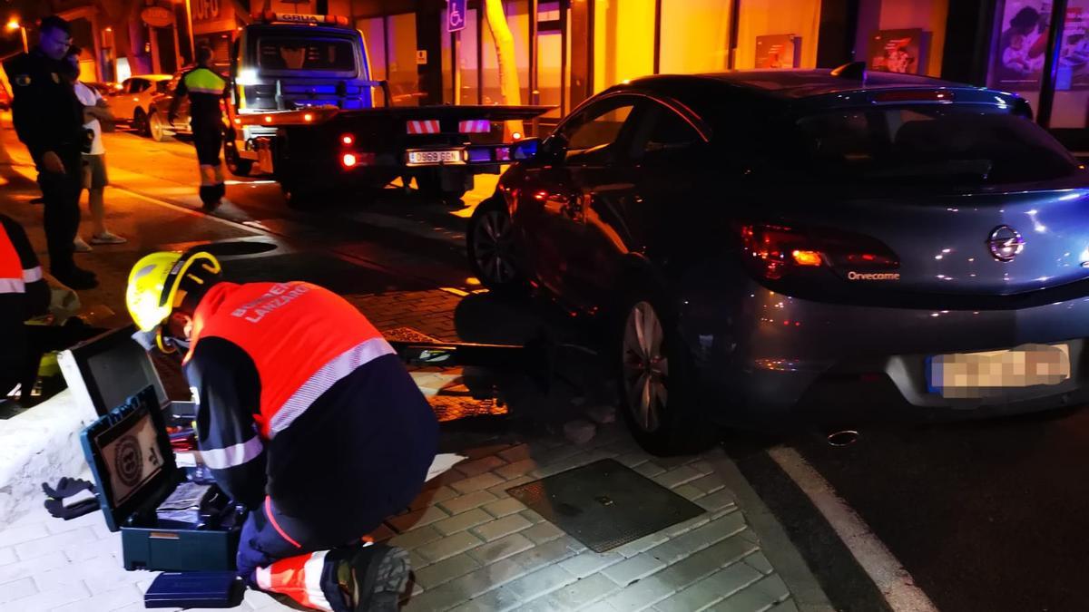 Un bombero junto al semáforo y el vehículo que lo tiró al suelo en Arrecife.