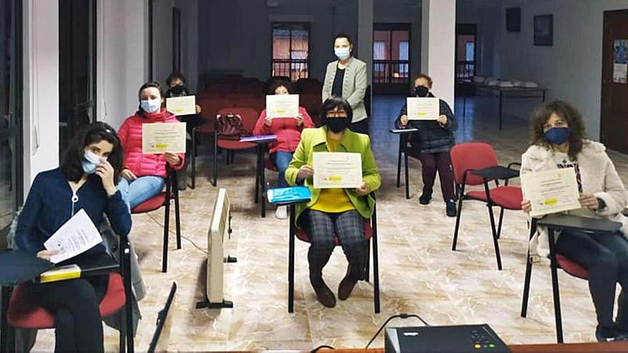 Participantes en una de las acciones formativas muestran el diploma que acredita su formación. | M. J. C.